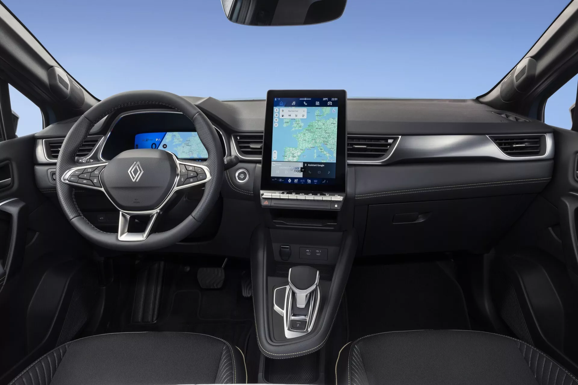 Interiér modelu Renault Symbioz 2024 (1. generácia) zobrazujúci palubnú dosku, volant a stredovú konzolu z pohľadu zadných sedadiel. Kľúčové prvky zahŕňajú trojramenný volant s integrovanými ovládacími prvkami, plne digitálny prístrojový panel, veľký vertikálne orientovaný dotykový infotainment systém, minimalistické ovládanie klimatizácie a elegantnú radiacu páku. Dizajn zdôrazňuje modernú technológiu a čistú, nepreplnenú estetiku s tmavými tónmi, ktoré dodávajú luxusný vzhľad.