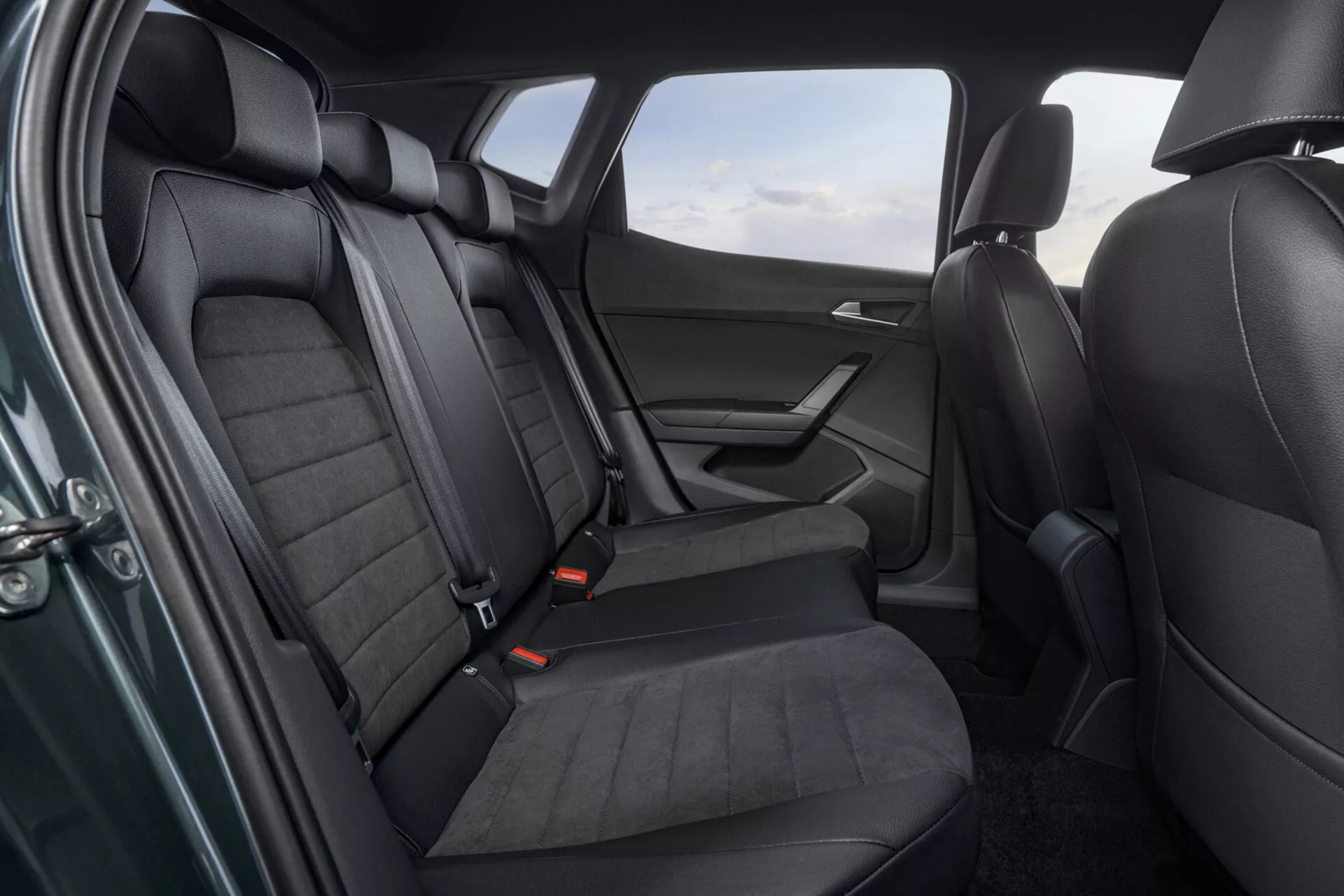 Interiérový záber Seat Arona 2017 ukazujúci zadnú časť sedadiel s detailným pohľadom na sedadlá potiahnuté kožou, dverný panel a bezpečnostné prvky z mierne zvýšeného uhla