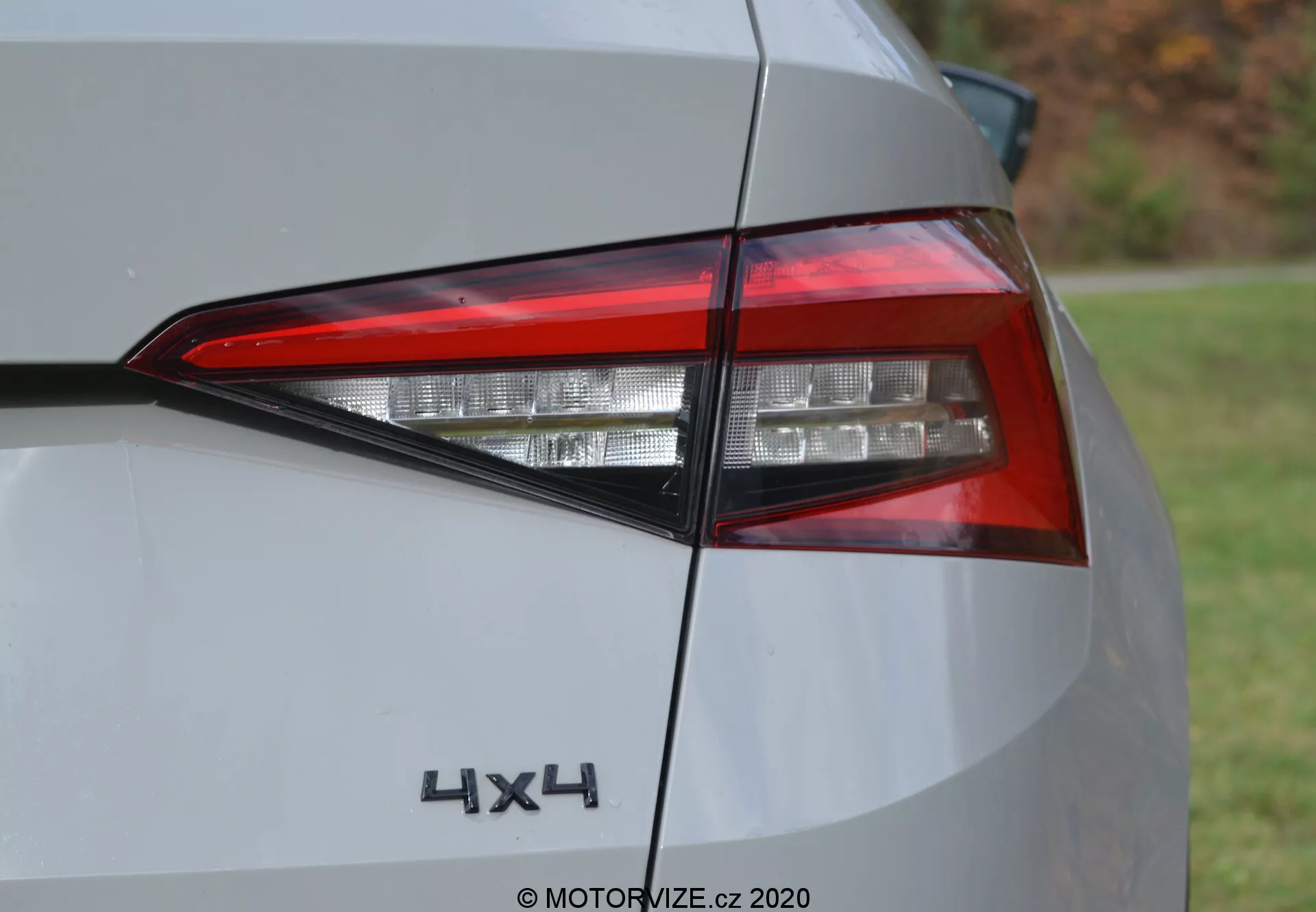 Detailný pohľad na zadnú časť vozidla Škoda Kodiaq 2017, ktorý zvýrazňuje súčasný LED svetelný systém a znak '4x4'. Uhlový záber ukazuje zložité vrstvy svetelných prvkov, hranatý dizajn a časť zadného panelu vo farbe striebornej alebo svetlosivej. Denná fotografia s prirodzeným osvetlením.