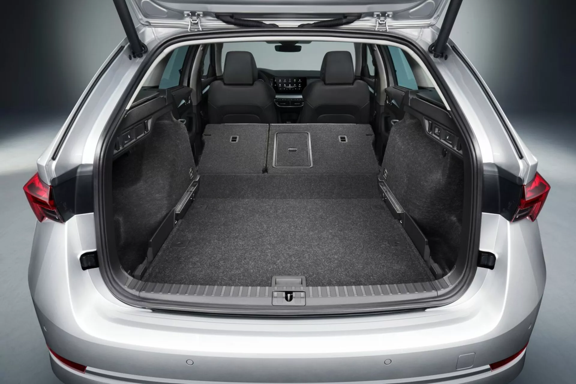 Otvorený kufor hatchbacku Škoda Octavia 2017 ukazujúci priestranný nákladný priestor so sklopenými zadnými sedadlami, plochou podlahou, kobercovým čalúnením, bodmi ukotvenia pre bezpečné ukladanie a možnými pokročilými technickými vlastnosťami ako sú LED svetlá
