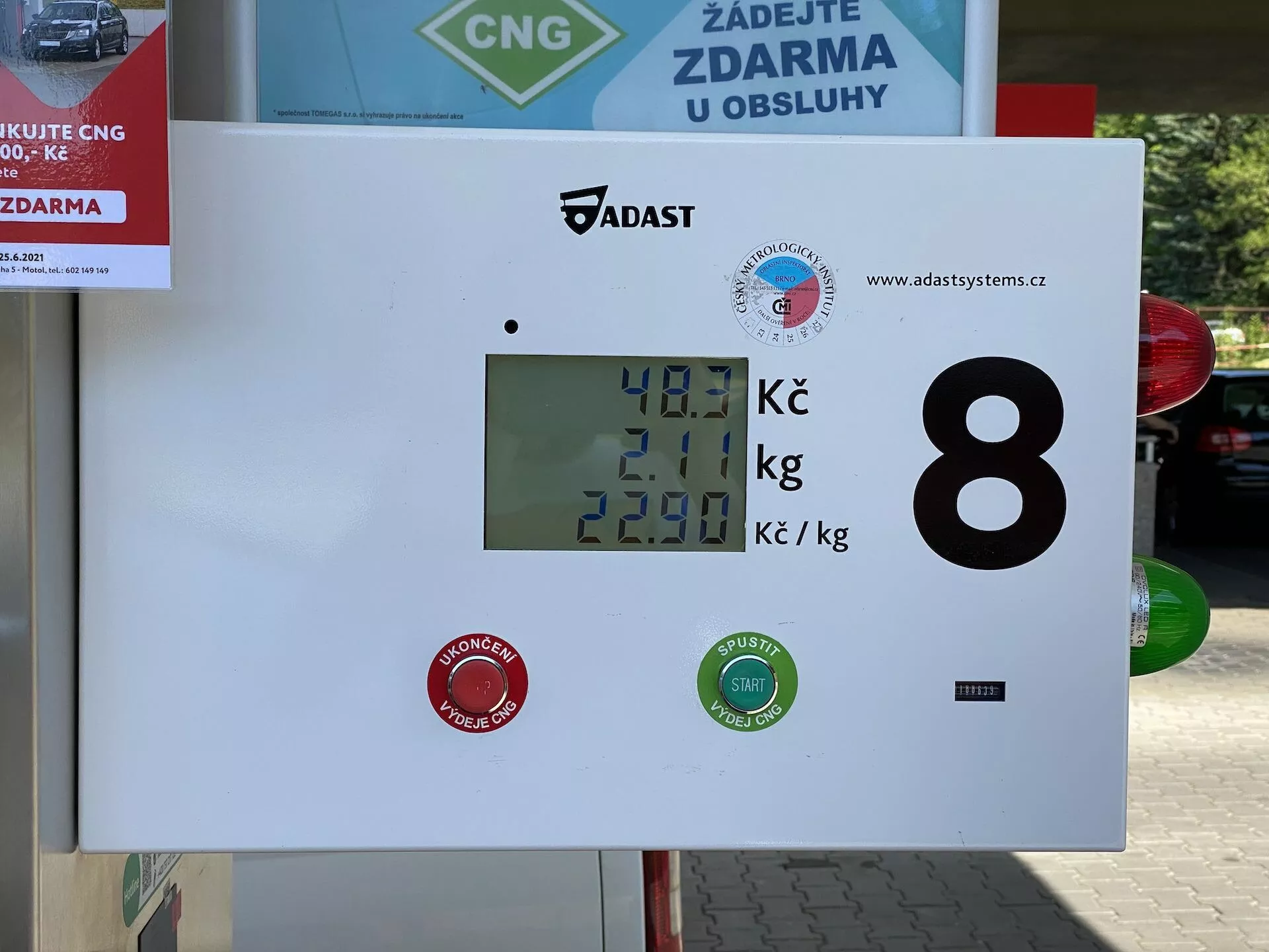 Displej čerpadla pre stlačený zemný plyn (CNG) na čerpacej stanici, ktorý zobrazuje 40,1 Kč za množstvo paliva, 2,01 kg ako hmotnosť plynu a cenu 22,90 Kč za kilogram. Displej obsahuje logá značiek a číselný identifikátor 8, s vonkajším prostredím naznačeným značkou autoumývarky alebo služby v pozadí.