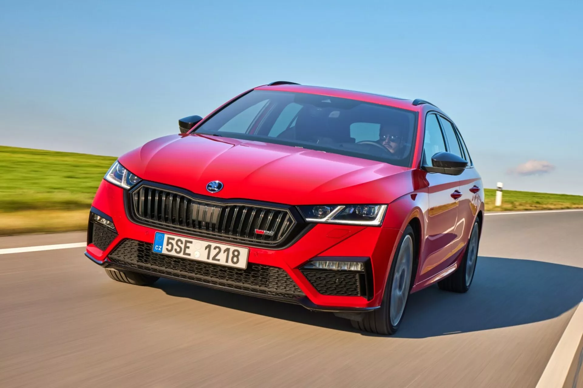 Škoda Octavia RS hatchback 2017 v dynamickom pohybe na spevnenej ceste, predvádza športový červený dizajn s čiernymi akcentmi, LED svetlomety a pokročilé technologické funkcie vrátane ADAS a panoramatického strešného okna