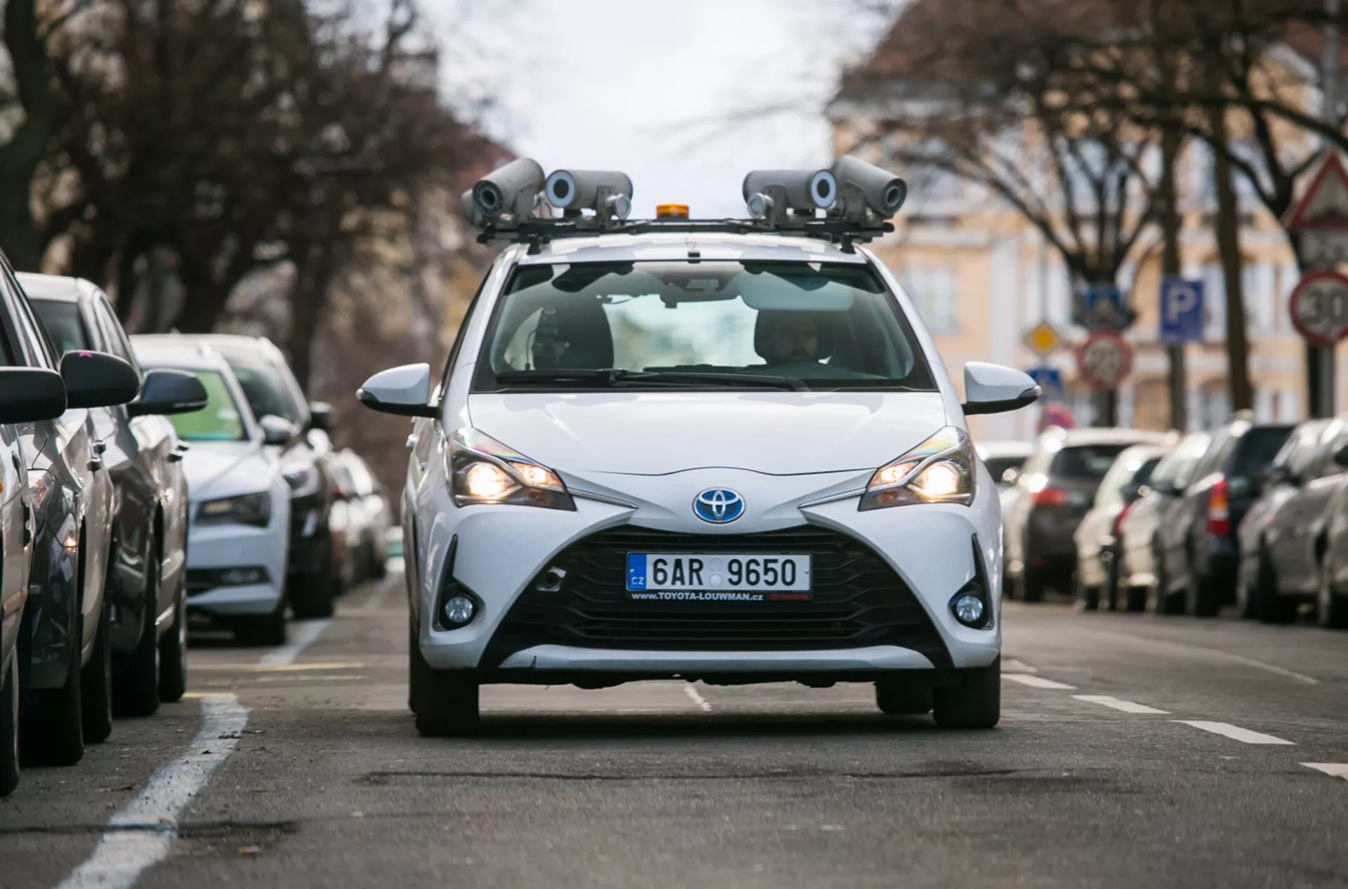 Hatchback Toyota 2017 vybavený LiDAR senzormi a kamerami pre technológiu autonómnej jazdy, zachytený z prednej perspektívy na mestskom ulici