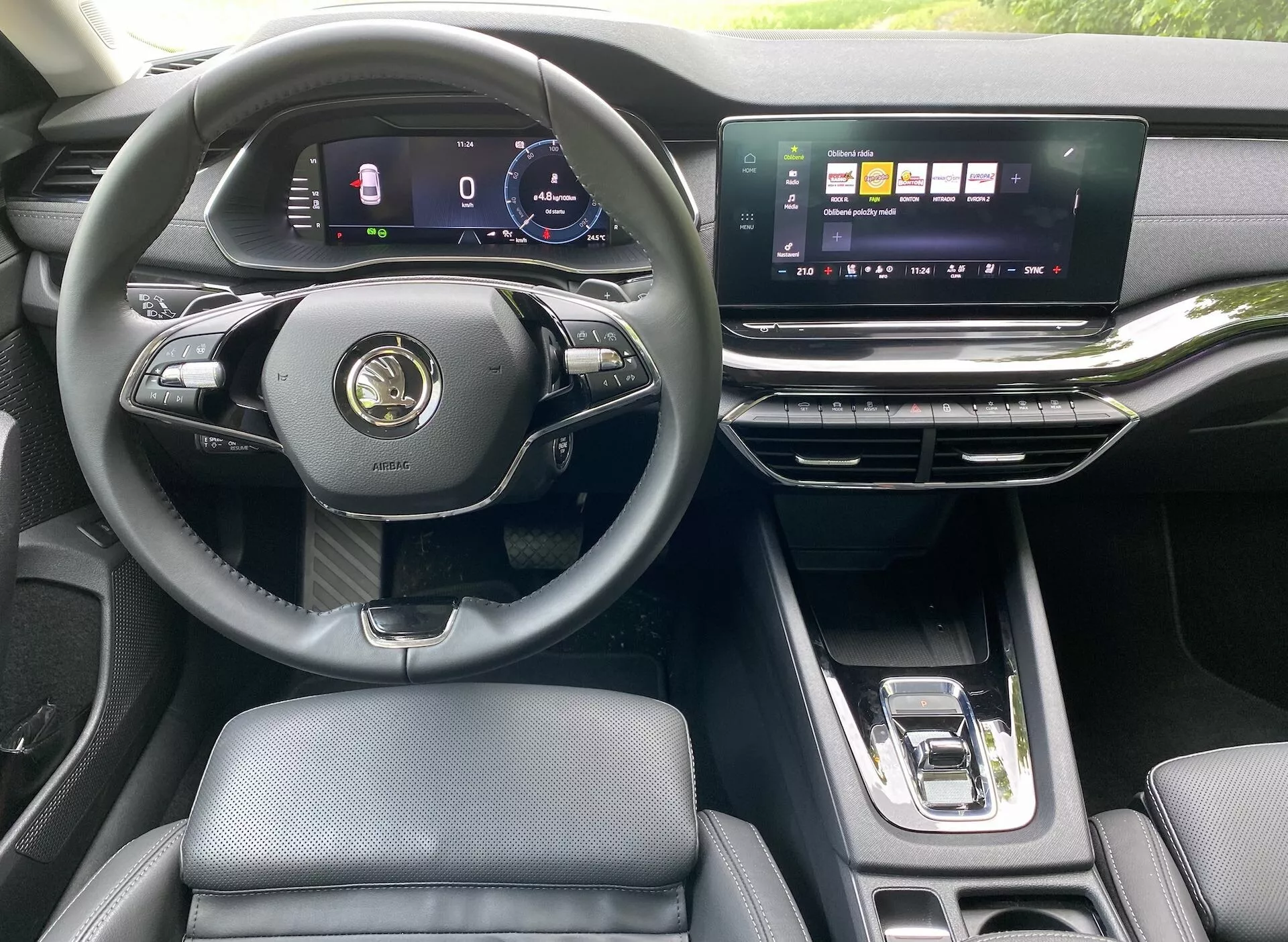 Interiér moderného vozidla Skoda Octavia Limousine 2020, zvýrazňujúci pohľad vodiča s trojramenným multifunkčným volantom, digitálnym prístrojovým panelom, širokou horizontálnou dotykovou obrazovkou infotainmentu, elegantnými odvetrávacími otvormi a automatickou radiacou pákou. Luxusný interiér zahŕňa kožené sedadlá a kovové akcenty.