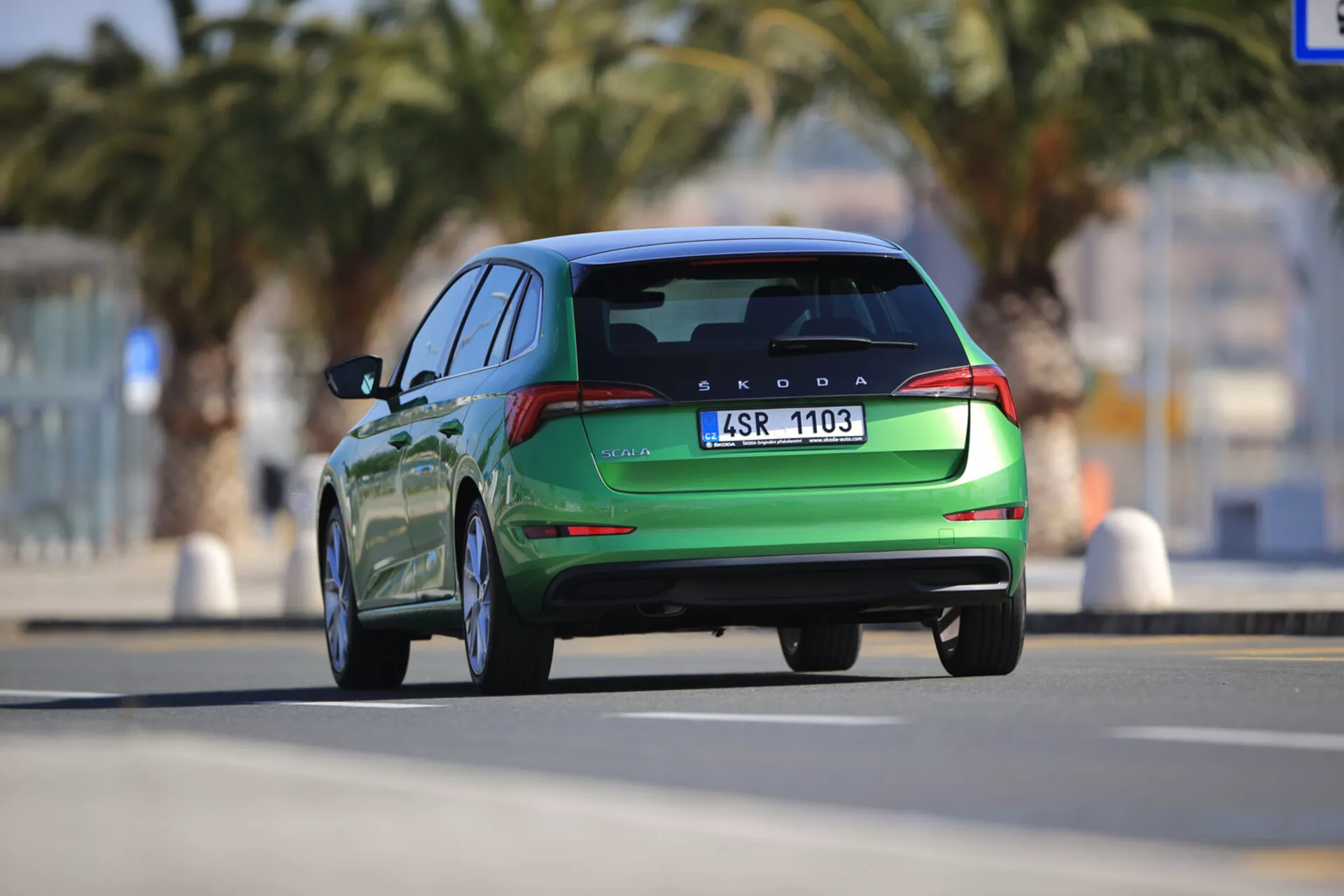Škoda Scala 2019 v pohybe zobrazená z zadného pohľadu, predvádzajúca moderné dizajnové prvky vrátane LED zadných svetiel, integrovaného zadného spojlera a dvojitých výfukových špičiek, zachytená z dynamického nízkeho uhla.