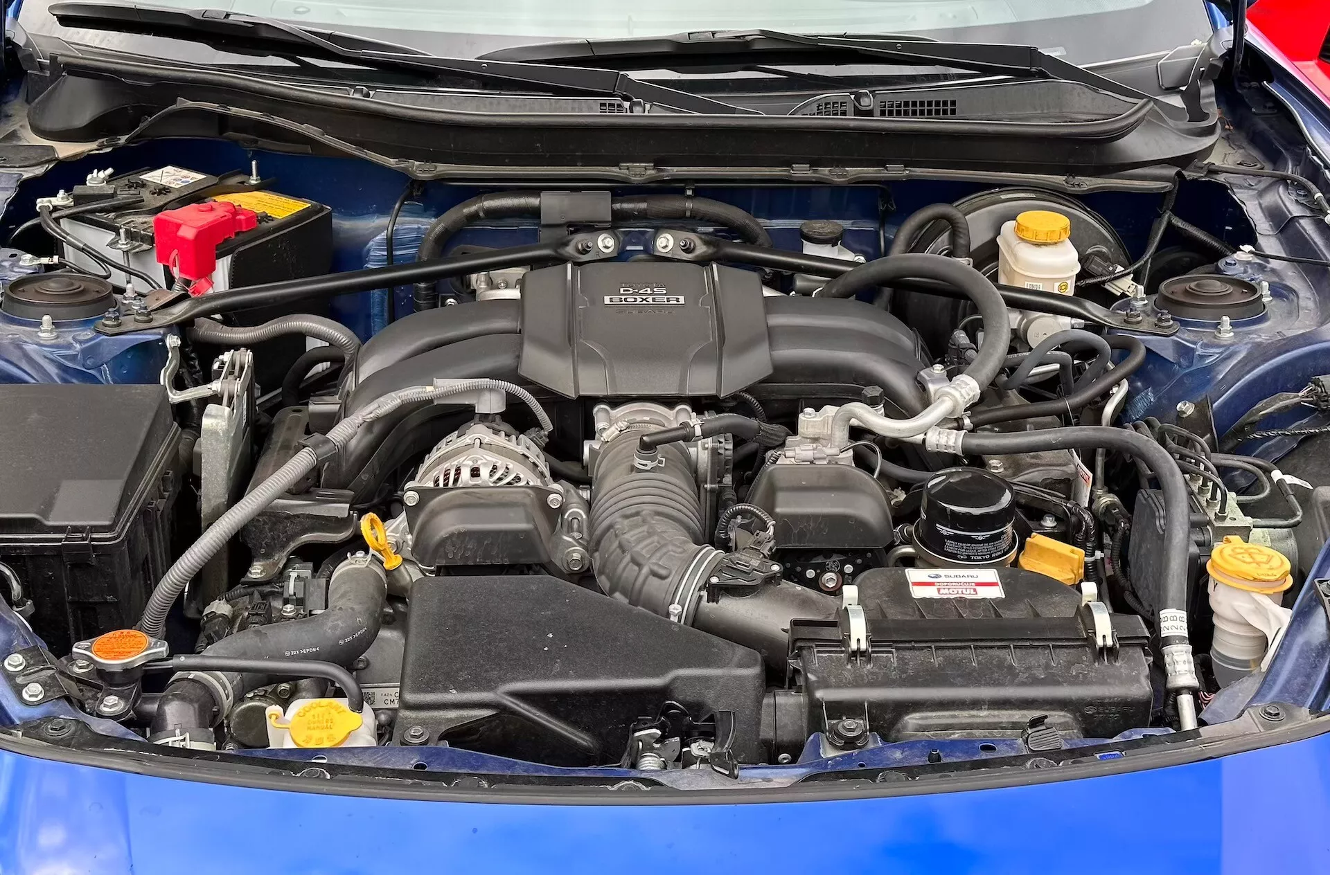 Podrobný pohľad na motorový priestor Subaru BRZ 2023 s motorom BOXER, batériou, nádržkami na kvapaliny a sústavou prívodu vzduchu