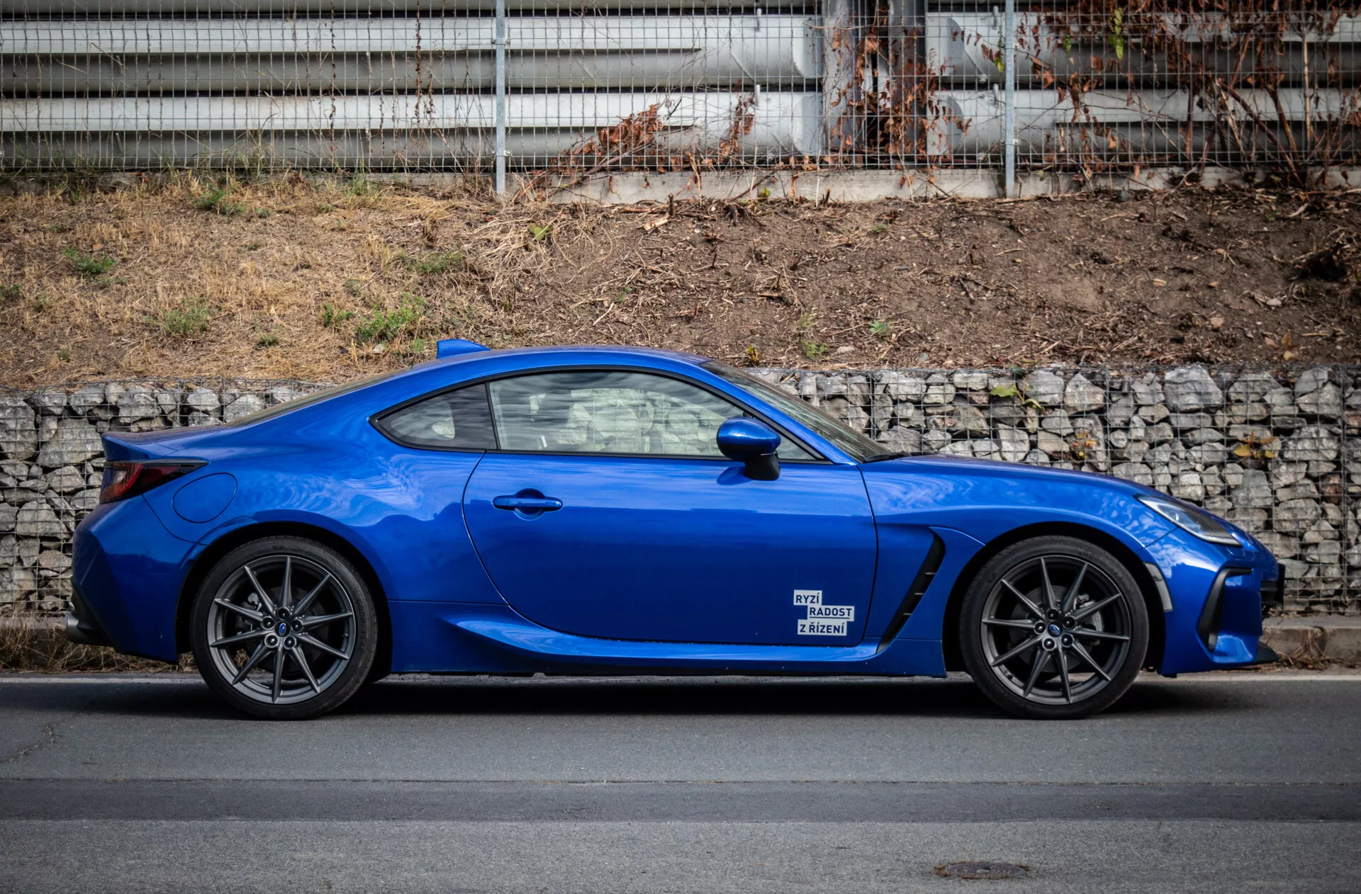 Subaru BRZ 2023 zaparkované v mestskom prostredí, predvádzajúce svoj elegantný dizajn a živú modrú farbu