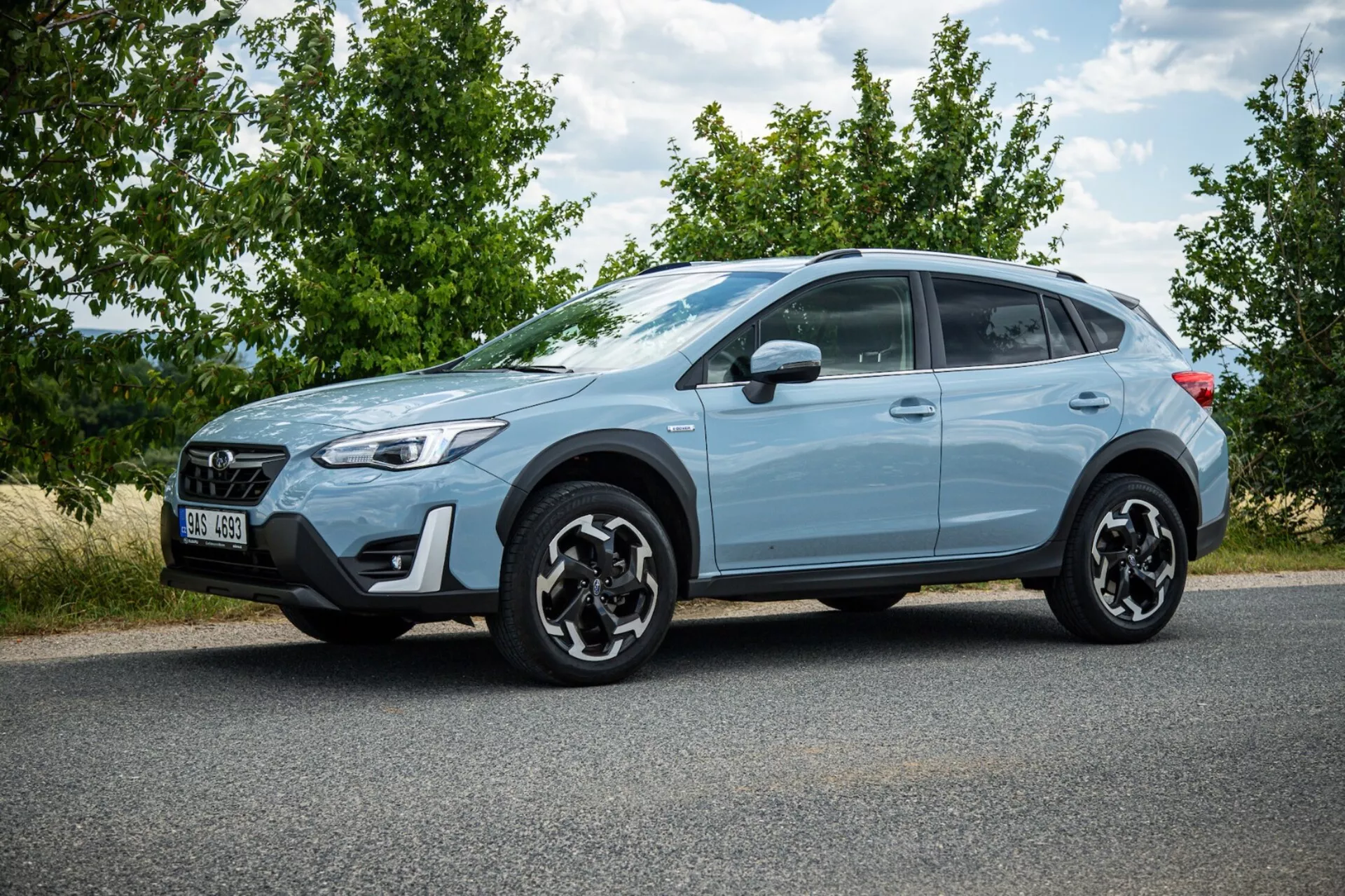 SUV crossover Subaru XV 2021 svetlomodrej farby zaparkovaný na asfalte so zobrazovaním bočného profilu, výraznými čiernymi zliatinovými kolesami, LED zadnými svetlami, vysokou svetlou výškou pre mestské a ľahké terénne použitie a modernými bezpečnostnými prvkami