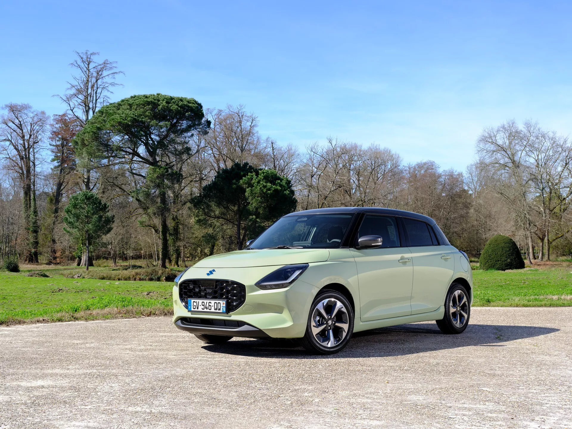 Suzuki Swift 2024, 7. generácia, zobrazené z uhla tri štvrtiny spredu, zdôrazňujúce jeho prednú mriežku, LED svetlomety, zliatinové kolesá a bočné kontúry v parkovom prostredí
