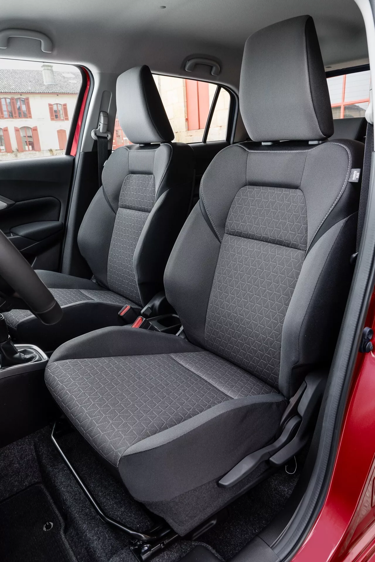 Interiér Suzuki Swift 7. generácie r. 2024 s dôrazom na zadnú pasažiersku časť s sedadlami z dvojfarebnej látky z pohľadu pravých dverí