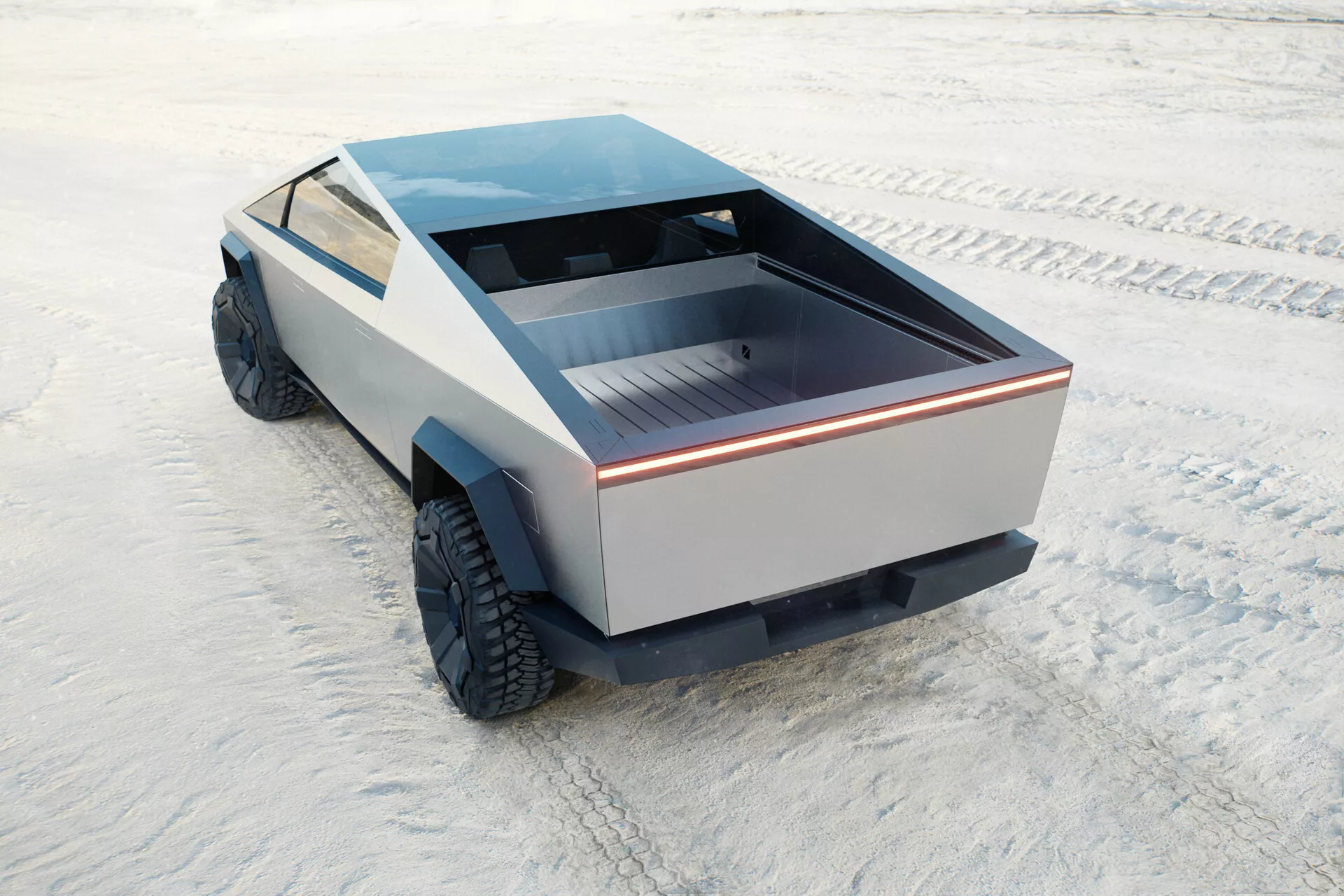 Futuristický a jedinečný Tesla Cybertruck 2021, prvá generácia, zachytený z vysokého zadného uhla. Pohľad zahrnuje zadnú korbu vozidla, časť jeho bočného profilu a plochú strechu. Zadná korba je plytká s plochým povrchom, ohraničená nepretržitým svetelným pásikom, ktorý zvýrazňuje moderný dizajn. Bočné panely postrádajú konvenčné štýlové prvky, predstavujúc minimalistický prístup. Veľké terénne pneumatiky naznačujú schopnosť jazdy v teréne. Absencia tradičných zrkadiel a výfukov naznačuje možný elektrický pohon. Nákladné auto je umiestnené na plochom, textúrovanom povrchu pripomínajúcom soľnú pláň.
