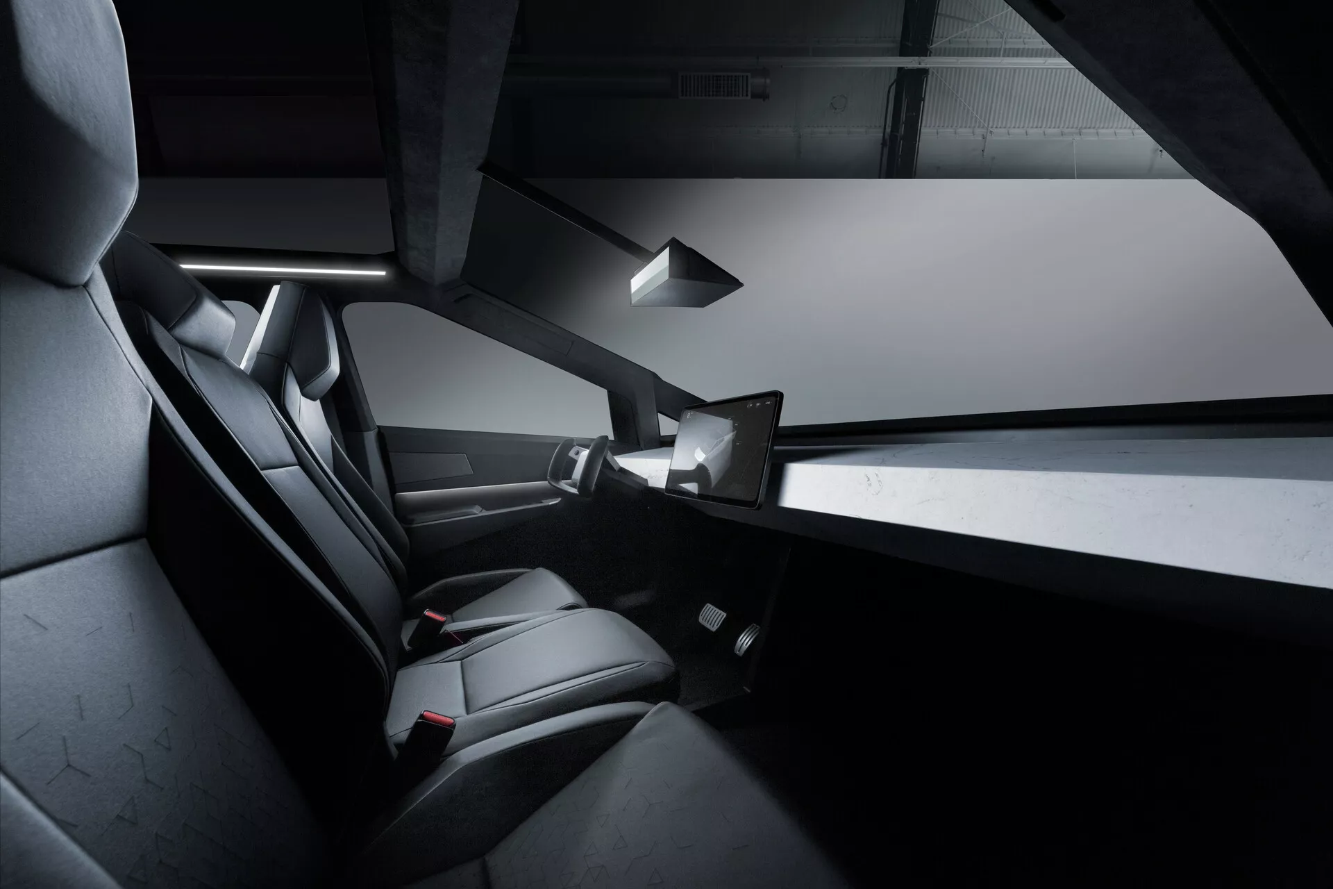 Pohľad na interiér Tesla Cybertruck 2021, zameraný na zadný priestor pre cestujúcich. Obrázok zdôrazňuje elegantné čierne, pravdepodobne kožené sedadlá pre dvoch s dôrazom na komfort a dizajn, čiastočne viditeľné bezrámové okná dverí, tenkú stredovú konzolu, horné interiérové osvetlenie a zadný dotykový displej. Dizajn je minimalistický s hranatými líniami a monochromatickým schémou.