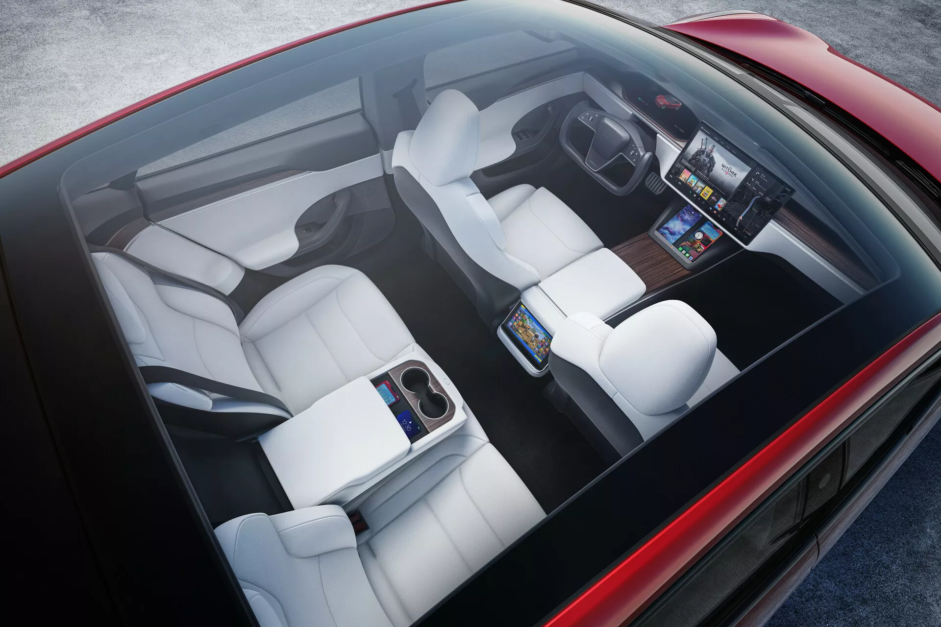 Pohľad zhora na interiér Tesla Model S 2016 (1. generácia, facelift). Interiér obsahuje biele čalúnené sedadlá s individuálnymi kontúrami, veľkú centrálnu dotykovú obrazovku na prednom paneli, digitálny prístrojový panel, minimalistickú stredovú konzolu a sklápateľnú opierku v zadnej časti. Demonštruje vyspelú technológiu, ergonomický dizajn a moderný luxus.