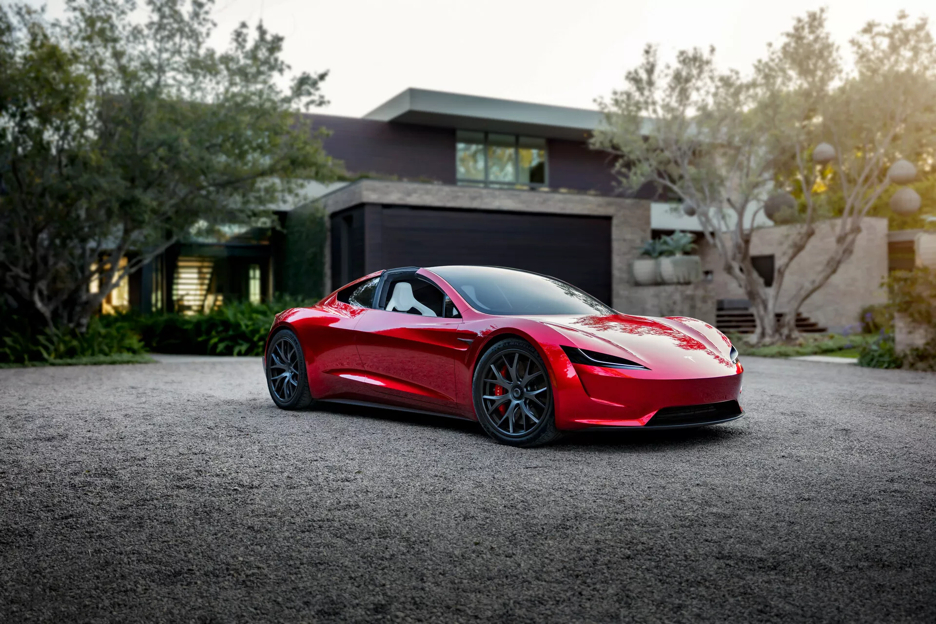 Tesla Roadster 2020 (2. generácia) v ohromujúcej červenej farbe. Predvádza elegantný aerodynamický dizajn s pokročilými funkciami vrátane vysoko výkonného elektromotora, maximálnou rýchlosťou cez 250 mph a zrýchlením z 0 na 60 za pouhých 1,9 sekundy.