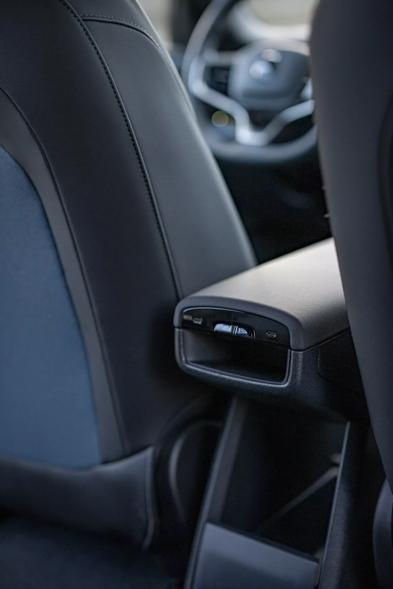 Interiérový pohľad na Volvo EX30 2024 zameraný na detailné funkcie zadného stredového konzolu z pohľadu stredného zadného pasažiera, vrátane USB portov a vzduchových otvorov, predstavujúci luxus a technológiu