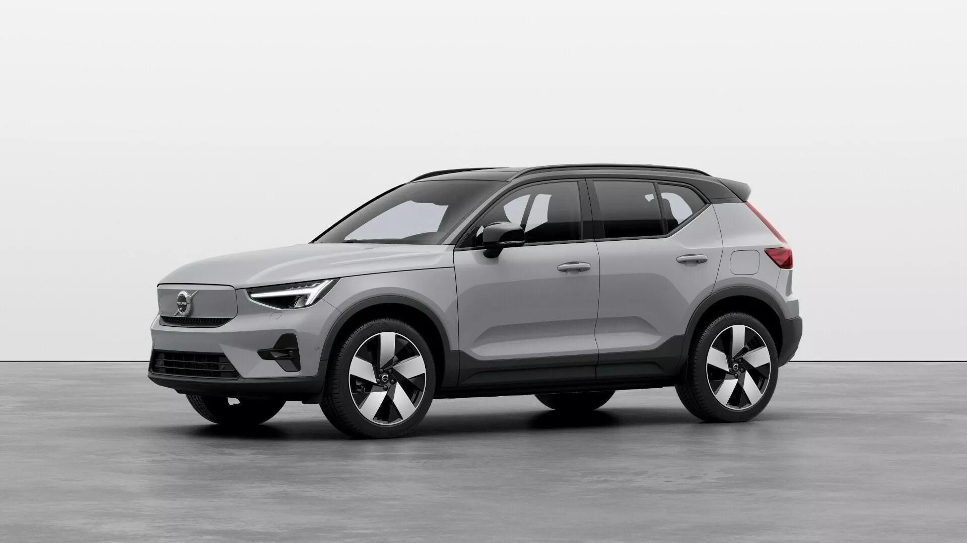 Elektrické SUV Volvo EX40 prvej generácie 2024 v štúdiu, ukazujúce predné a bočné profily s LED svetlometmi, uzavretou mriežkou, viacramennými zliatinovými kolesami a senzormi najnovšej technológie