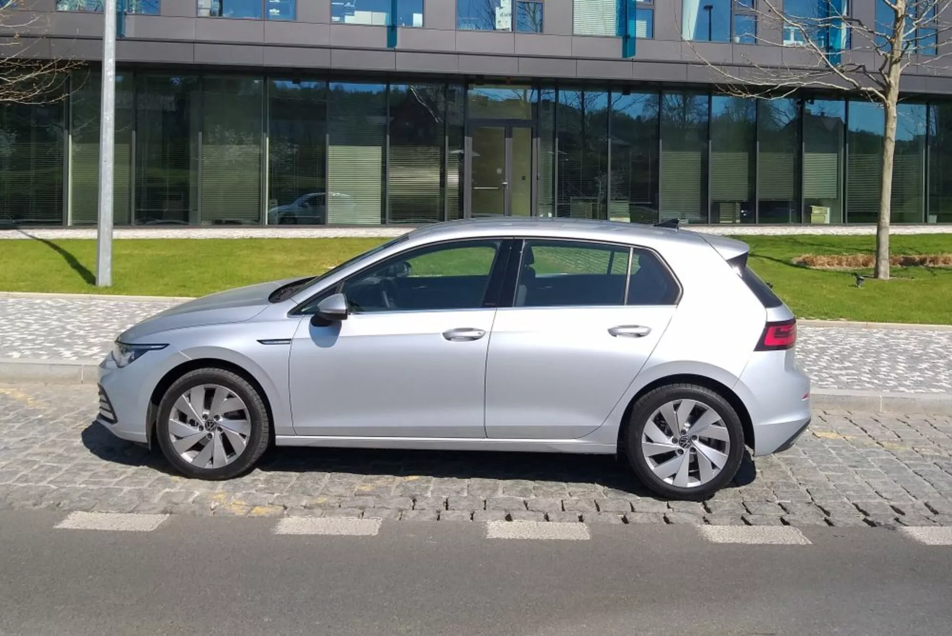 Strieborný hatchback VW Golf GTD z roku 2017 zaparkovaný na spevnenej ploche počas dňa za jasného neba, zobrazujúci bočný profil s diskami z ľahkej zliatiny a výraznými líniami karosérie