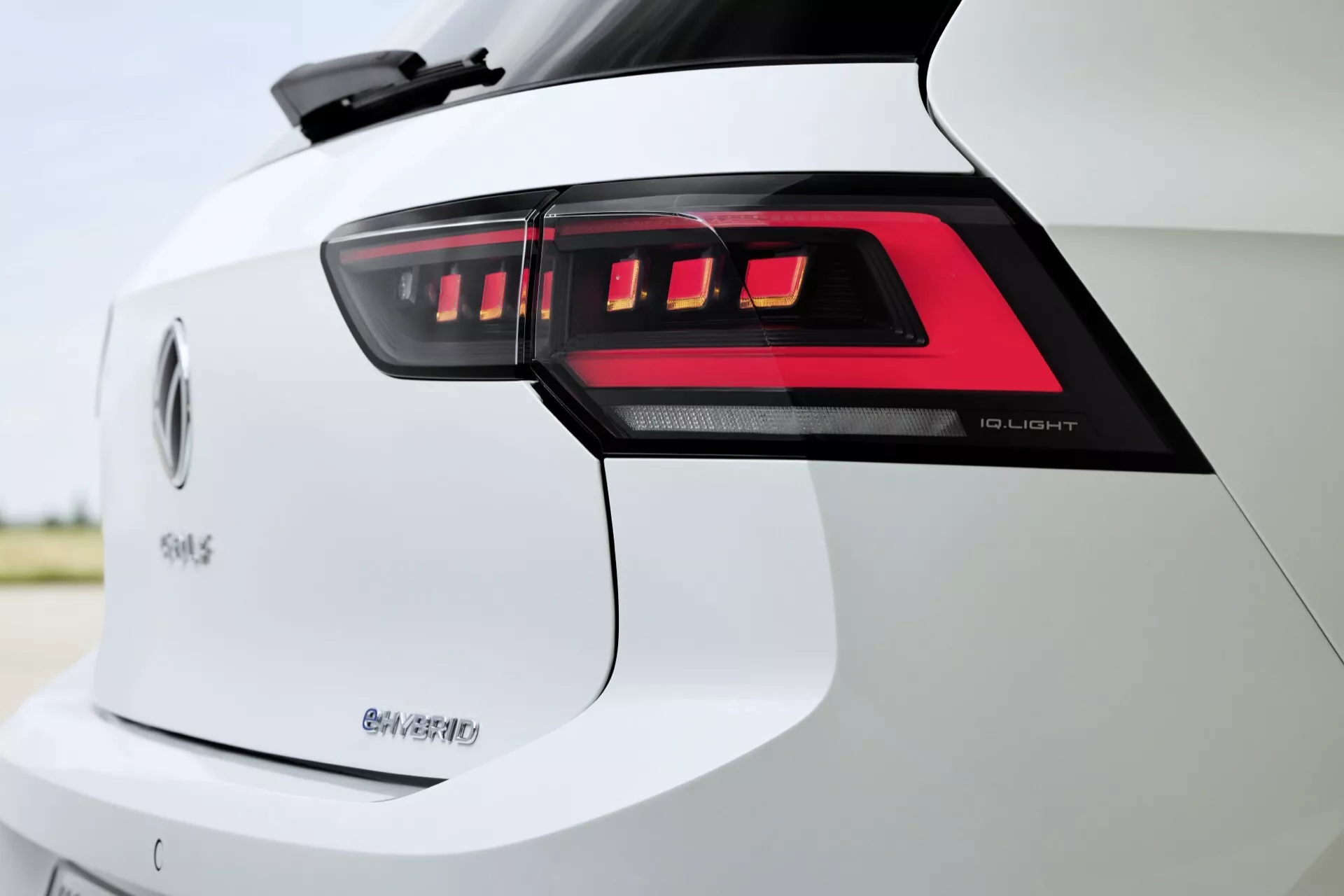 Detailný obrázok zadnej časti VW Golf 2024 (VIII-facelift) s LED zadnými svetlami, označeniami '50 e-tron' a 'Q4', zdôrazňujúci pokročilú LED svetelnú technológiu, elektrickú mobilitu a potenciálne schopnosti pohonu všetkých kolies v bielej exteriérovej úprave.