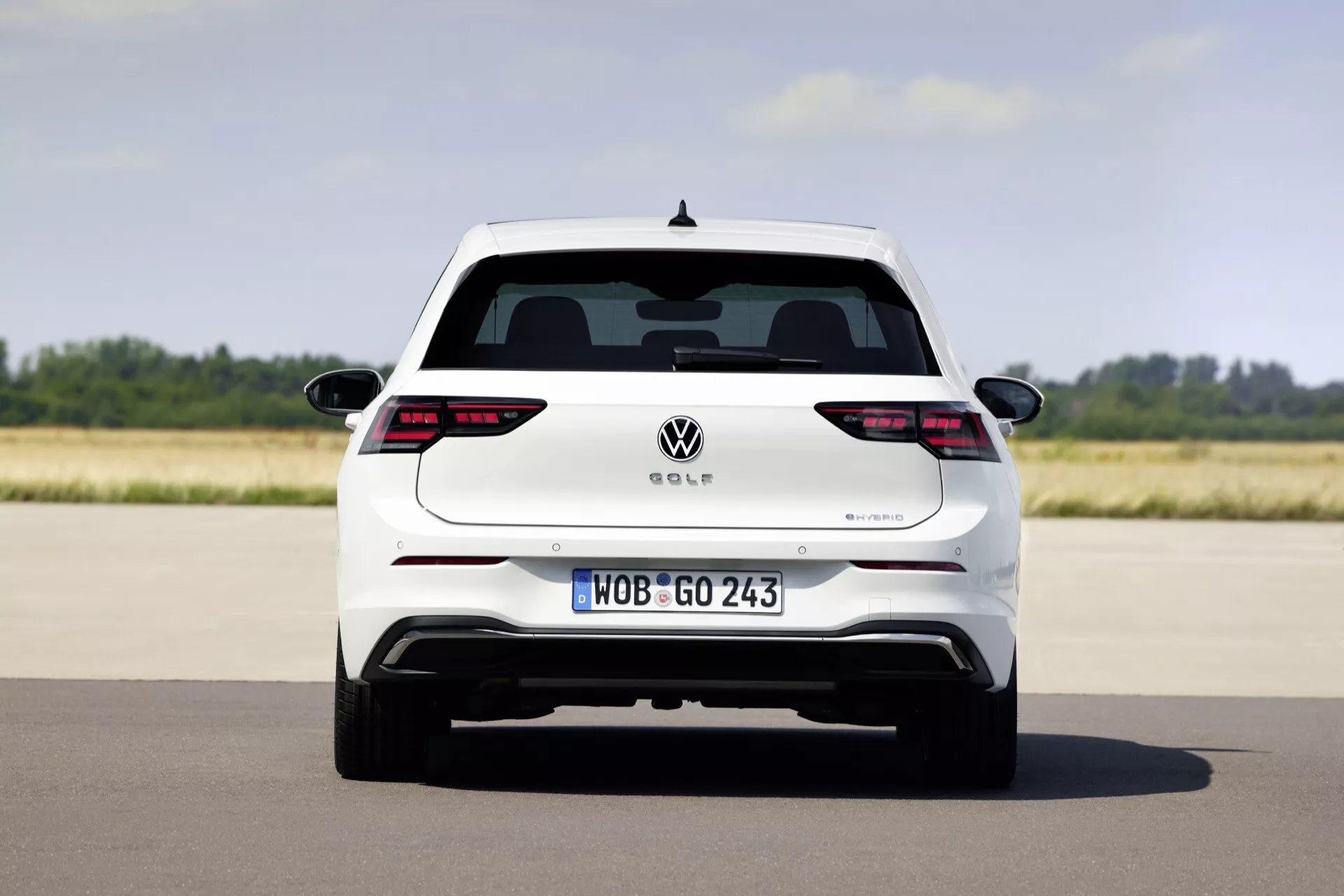 Volkswagen Golf VIII facelift 2024, zachytený z priameho zadného pohľadu, ktorý predvádza plnú šírku a dizajnové prvky ako LED zadné svetlá, európska poznávacia značka a potenciálny hybridný výfukový systém na otvorenej ceste.