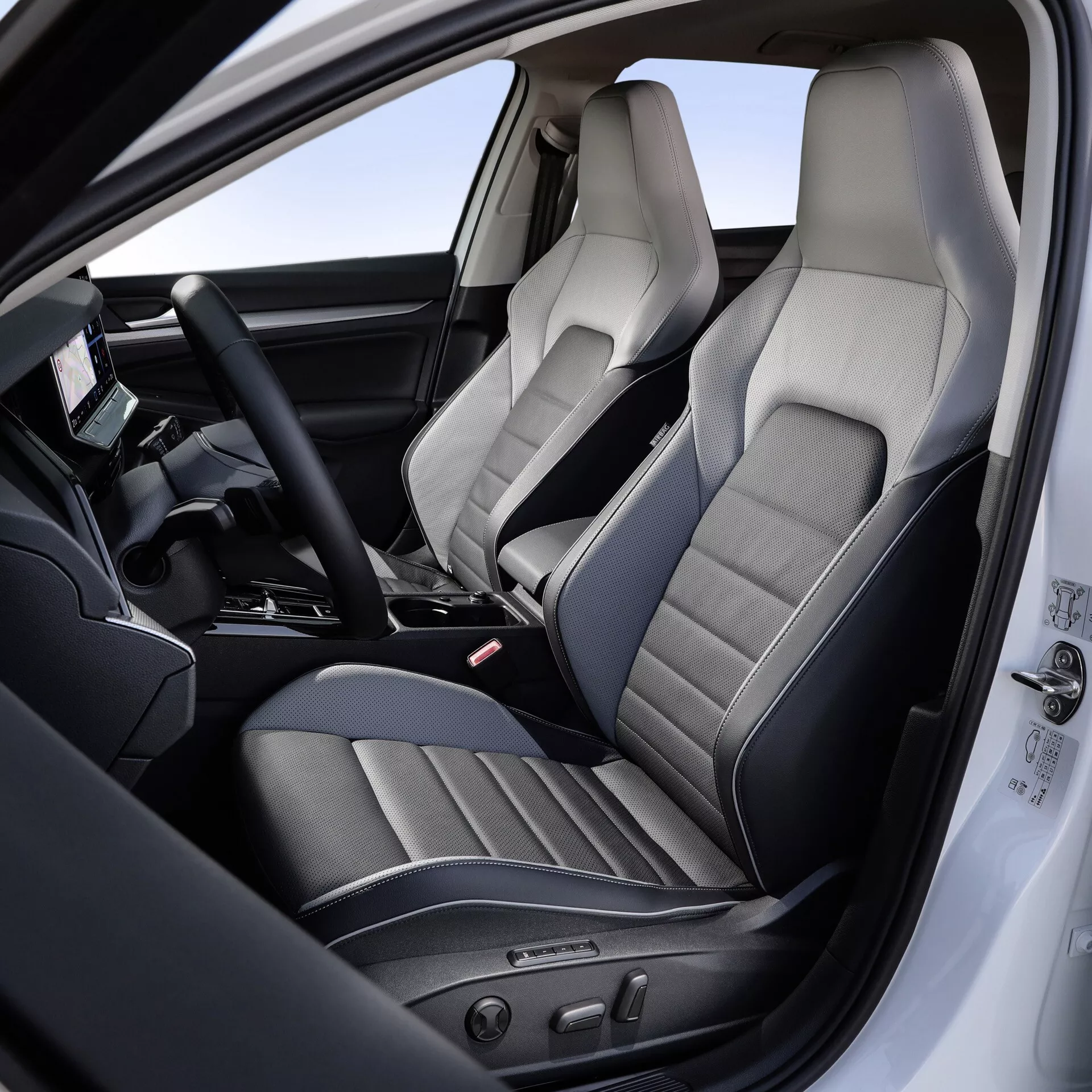 Interiér VW Golf 2024 (VIII-facelift) zobrazujúci oblasť vodiča a sedadlo spolujazdca, s dôrazom na sedadlá z prémiovej kože s detailným šitím, elektronické nastavenie sedadla, multifunkčný volant s digitálnym displejom a pokročilé funkcie stredovej konzoly.