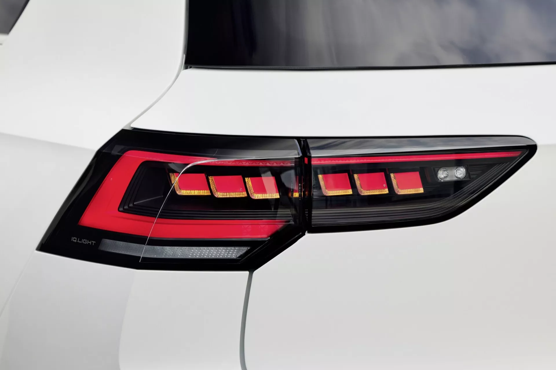 Detailný pohľad na pravé zadné svetlo VW Golf VIII facelift 2024 s horizontálnymi LED segmentmi a OLED technológiou na bielej vozidle