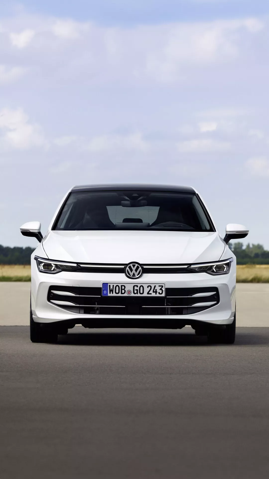 Predný pohľad na VW Golf (VIII Facelift) 2024 na spevnenej ploche ukazujúci jeho mriežku, elegantné LED svetlomety, emblem a aerodynamický dizajn kapoty, naznačujúci modernú technológiu a športovú estetiku.