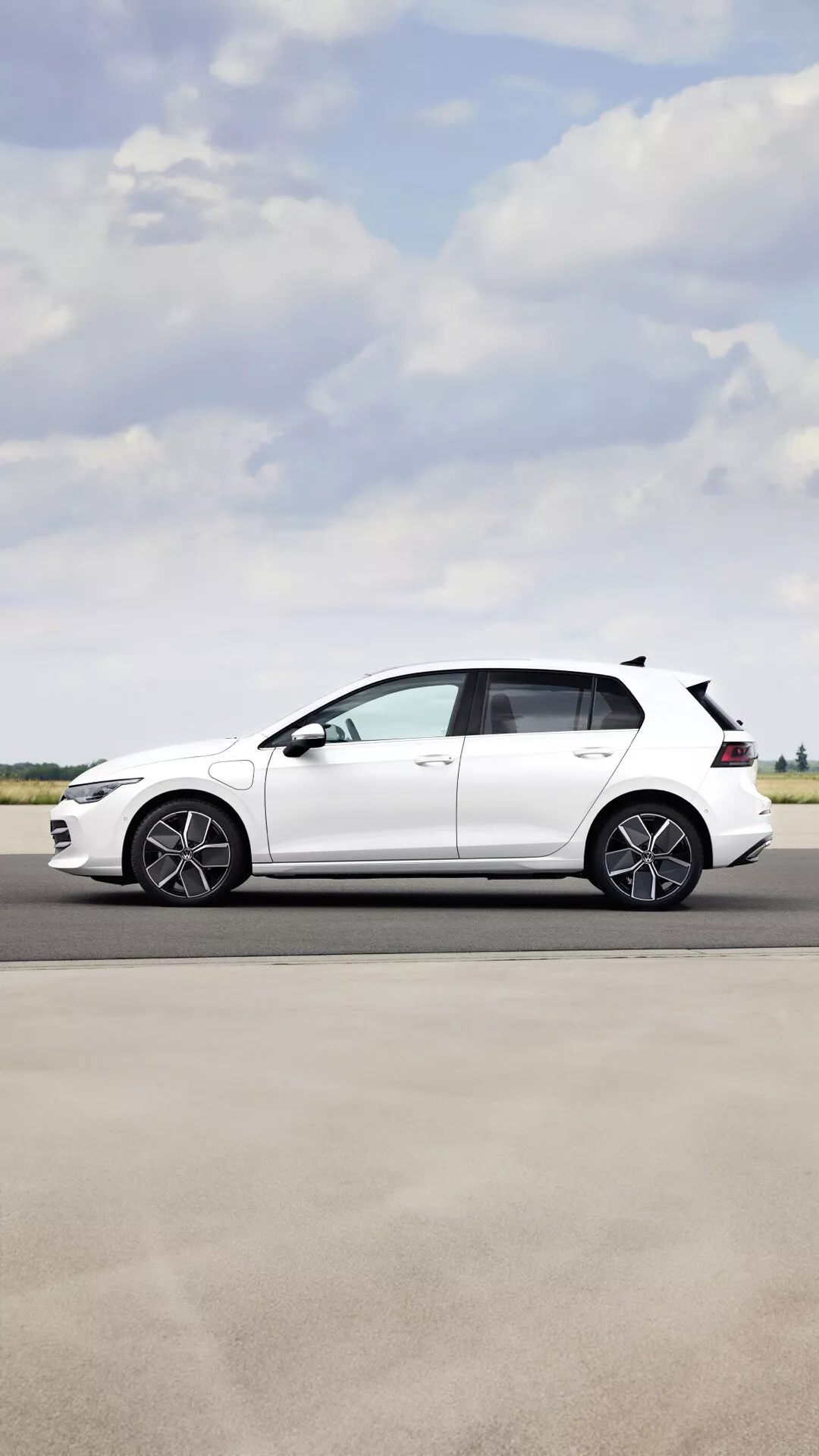 Bočný pohľad na Volkswagen Golf VIII Facelift 2024 so športovými zliatinovými kolesami, kĺzavou strešnou líniou a bielym lakovaním na jasnom vonkajšom dni
