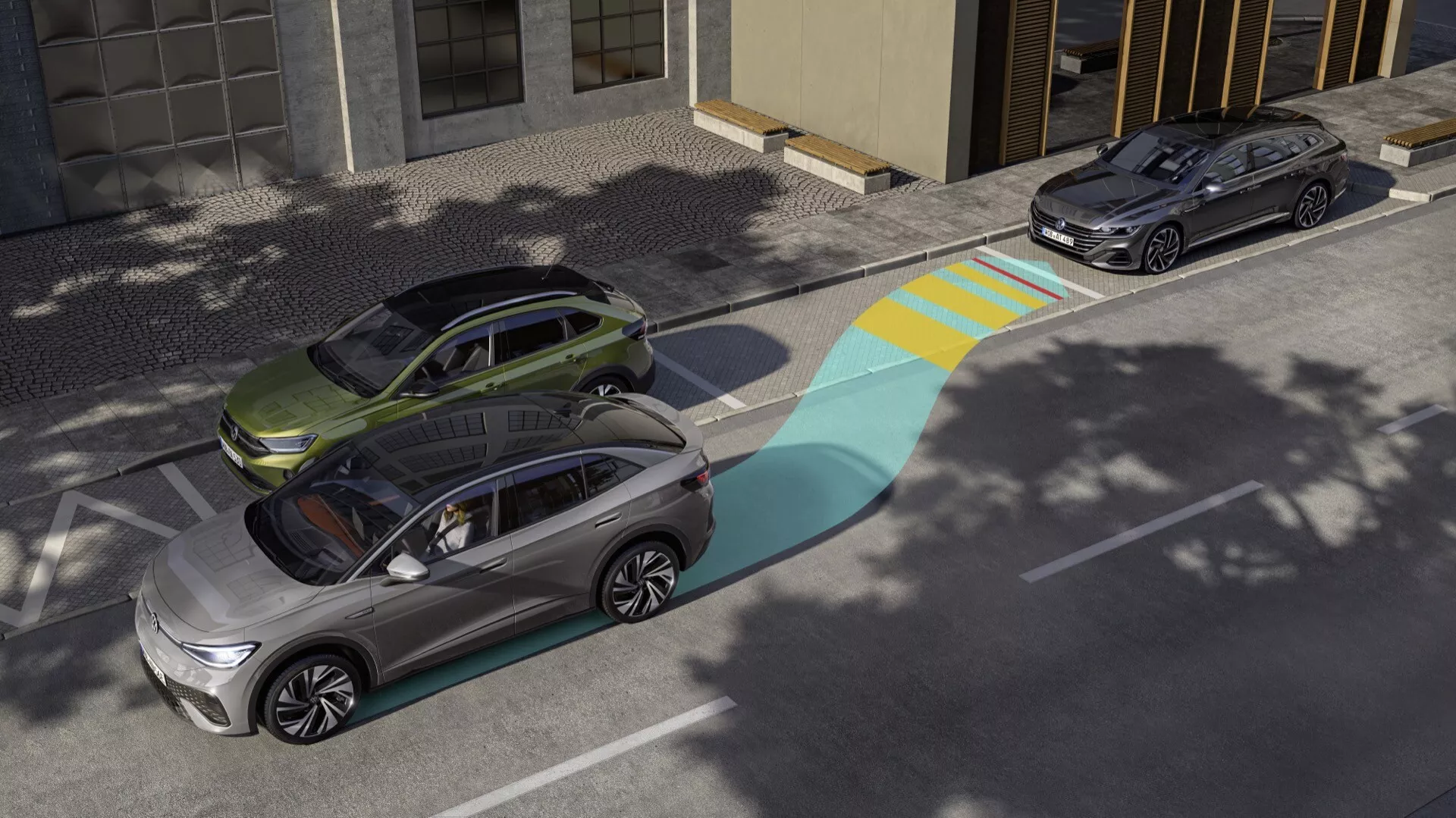 Pohľad z vysokého uhla na dve moderné elektrické SUV prezentujúce pokročilé technologické funkcie, ako je prekrytie rozsahu snímačov jedného z vozidiel. Predné vozidlo v metalickej striebornej farbe zobrazuje modro-žltú grafiku svojho asistenčného systému vodiča, zvýrazňujúcu jeho detekčnú oblasť. Za ním je zaparkované tmavšie SUV, možno tmavosivé alebo čierne, v mestskej oblasti za silného slnečného svetla.