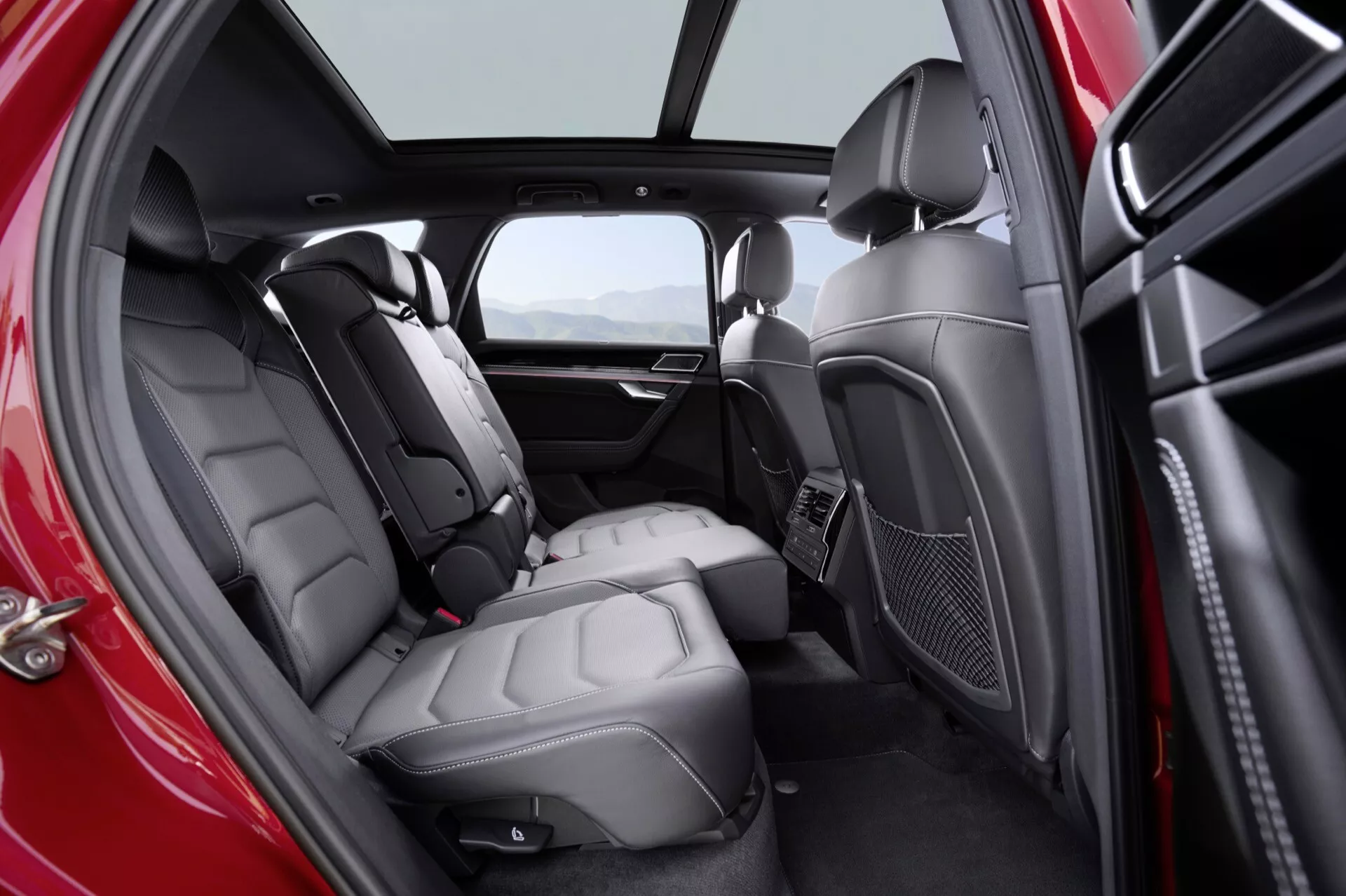 Interiér VW Touareg 2023 (III Facelift) s dôrazom na zadný cestujúci priestor s bohatým priestorom pre nohy, kožené sedadlá a vylepšené komfortné prvky vrátane klimatizácie a ambientného osvetlenia