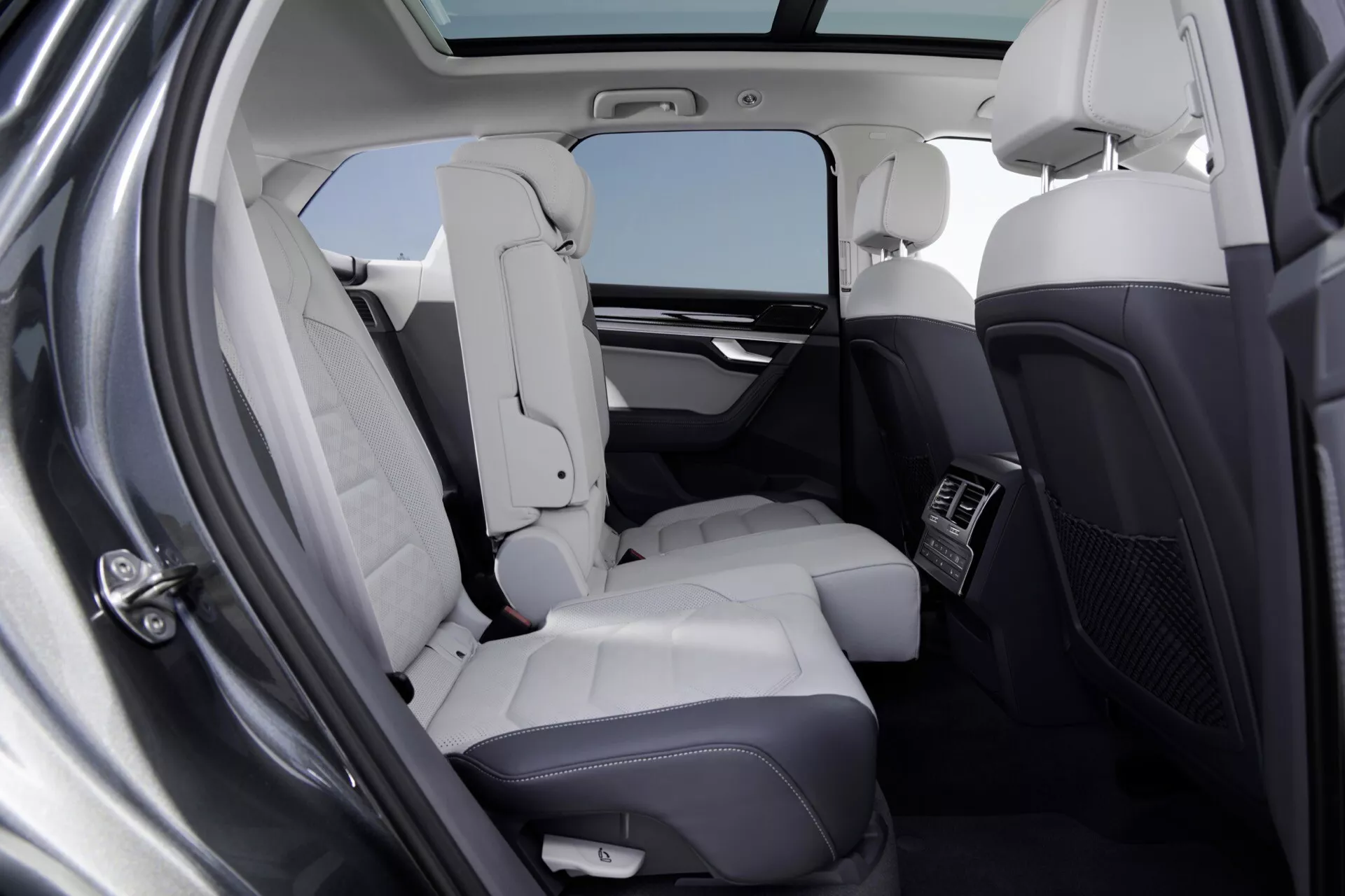 Interiér Volkswagen Touareg 2023 (III-Facelift) ukazujúci luxusný zadný pasažiersky priestor s ľahkými koženými sedadlami, panoramatickou strešnou oknou a priestorom na nohy