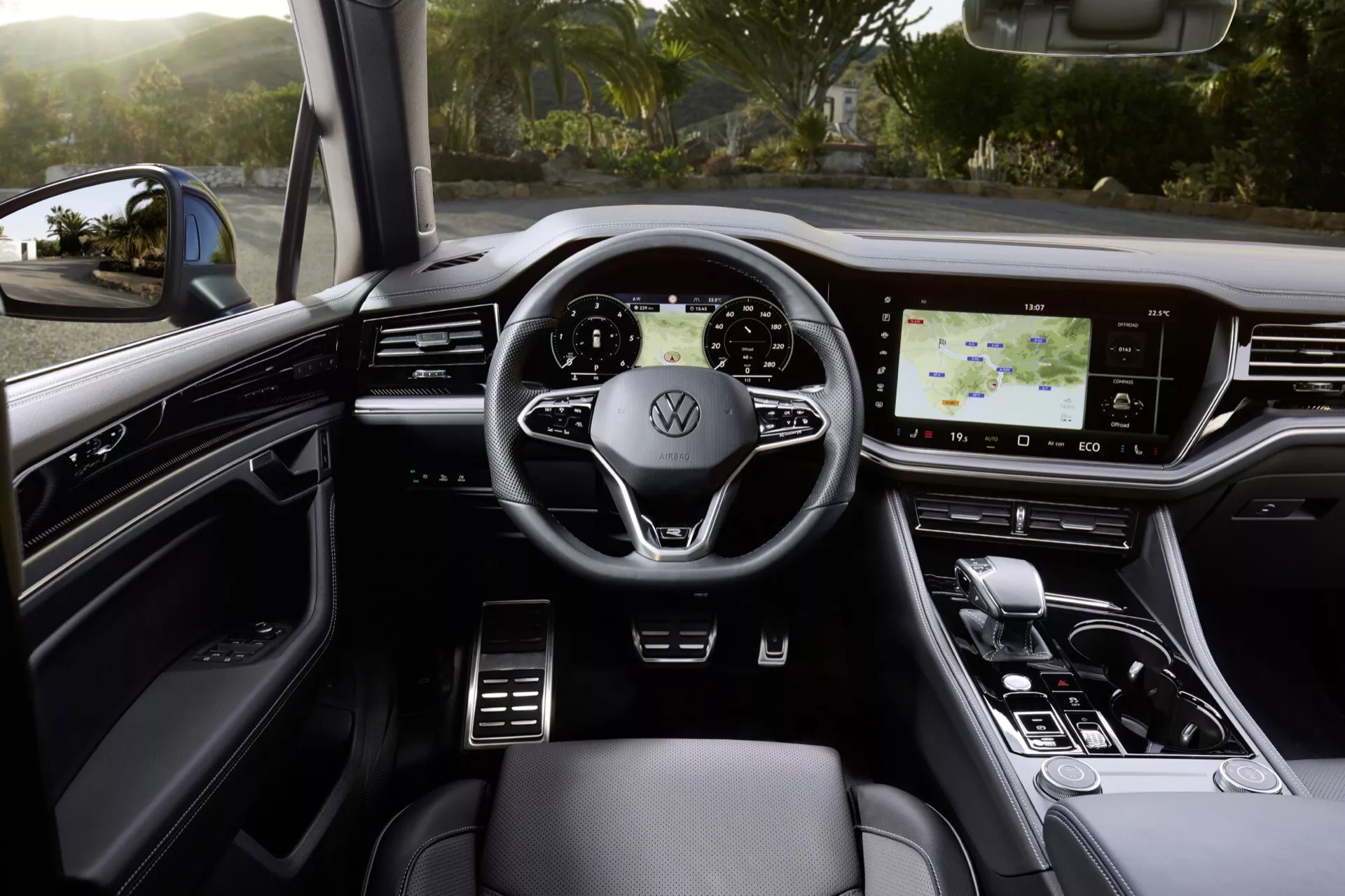 Interiér Volkswagen Touareg 2023 z pohľadu zo zadného sedadla ukazuje digitálny palubný panel, multifunkčný volant, dotykový infotainment systém a luxusné funkcie