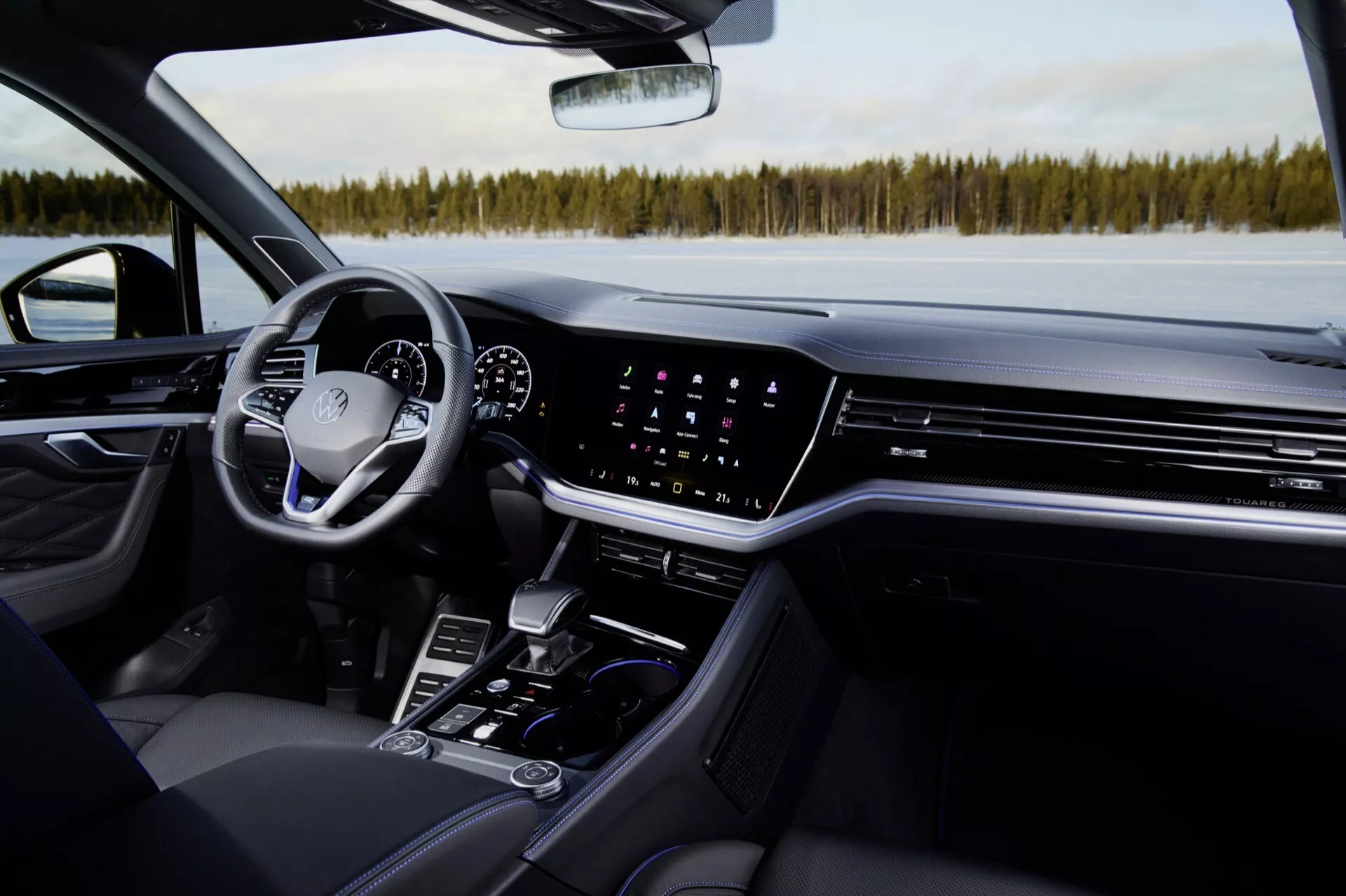 Interiér Volkswagen Touareg 2023: Pohľad z pasážerskej strany zdôrazňujúci palubnú dosku, dotykovú obrazovku infotainmentu, klimatizáciu, digitálny prístrojový panel, multifunkčný volant a prvky stredovej konzoly v modernom luxusnom automobile